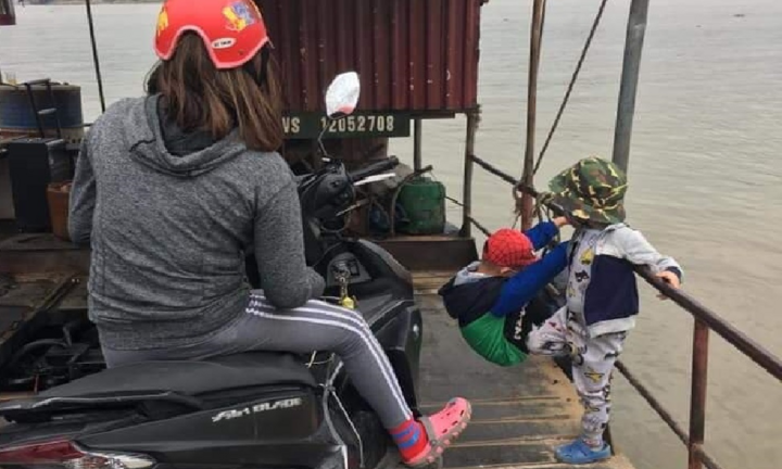 Người phụ nữ mải mê xem điện thoại bỏ mặc hai bé chơi nguy hiểm trên phà qua sông