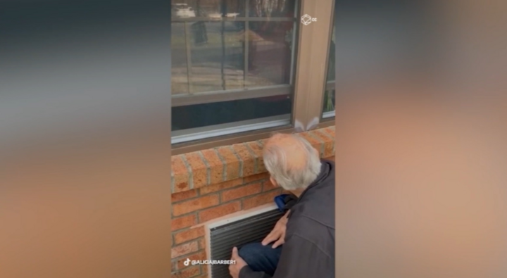 Cảm động tình yêu của vợ chồng già động viên nhau qua tấm kính cửa sổ