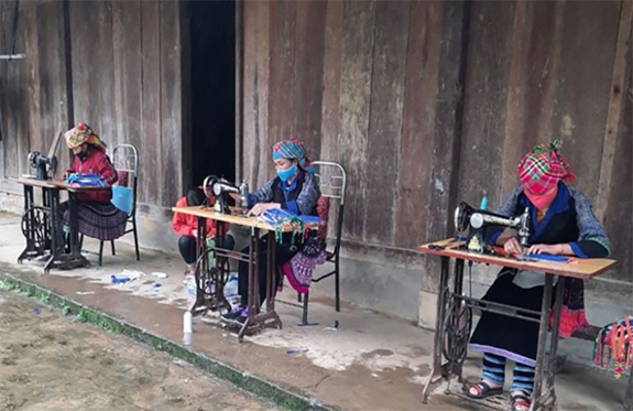 Phụ nữ dân tộc Mông ở Mù Cang Chải may khẩu trang tại nhà chống dịch COVID-19