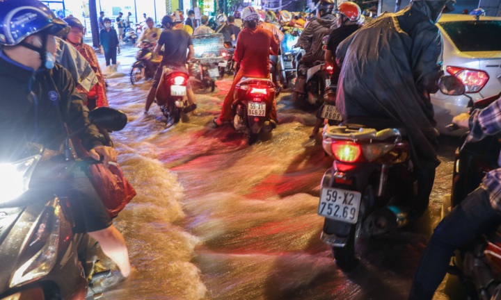 Nước đổ cuồn cuộn, xe máy chao đảo sau mưa lớn ở TP.HCM