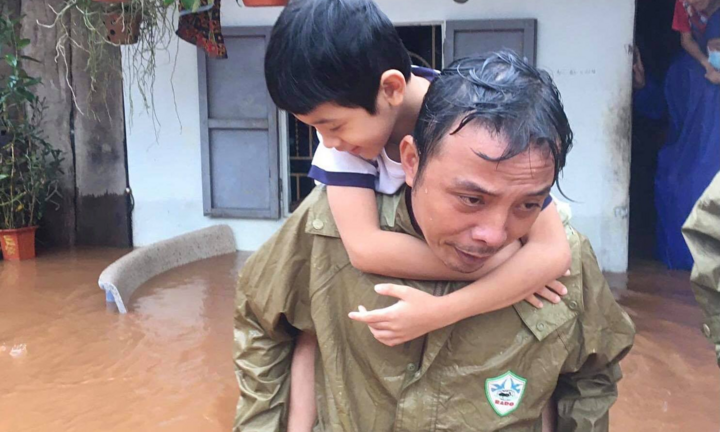 Ảnh: Công an dầm mưa, lội nước cõng dân đến nơi an toàn