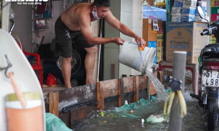 Ảnh: Triều cường đạt đỉnh, người dân TP.HCM hì hục tát nước ra khỏi nhà