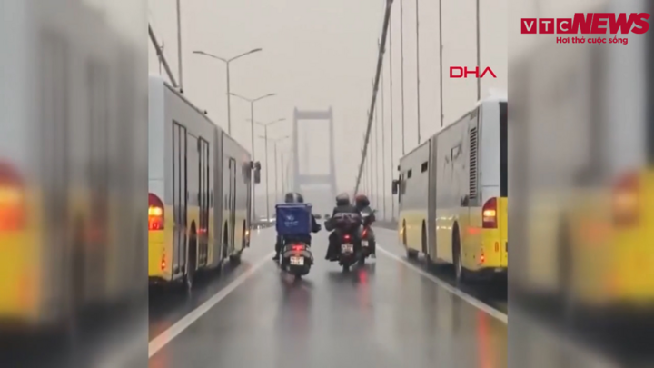 Video: Hai xe buýt chắn gió cho xe máy qua cầu