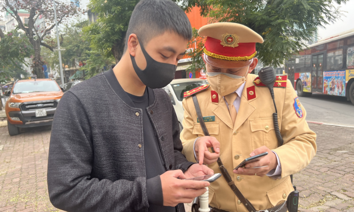 Ảnh: CSGT Hà Nội hướng dẫn người dân nộp phạt online trong ngày đầu triển khai