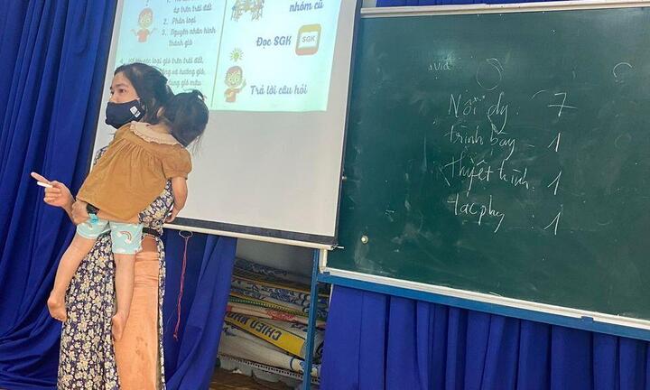Cô giáo vừa bế con ngủ trên tay vừa dạy học mùa dịch 