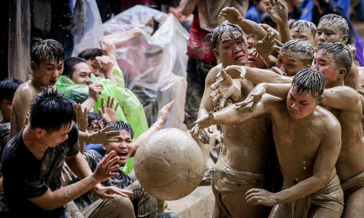 Ảnh: Nghìn người cổ vũ 16 thanh niên vật lộn trong bùn tranh quả cầu gỗ