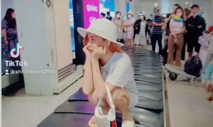 Xác minh nữ hành khách ngồi trên băng chuyền chờ hành lý ở sân bay
