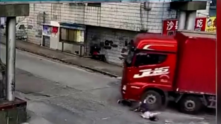 Video: Va chạm với xe tải, người phụ nữ suýt bị cuốn vào gầm