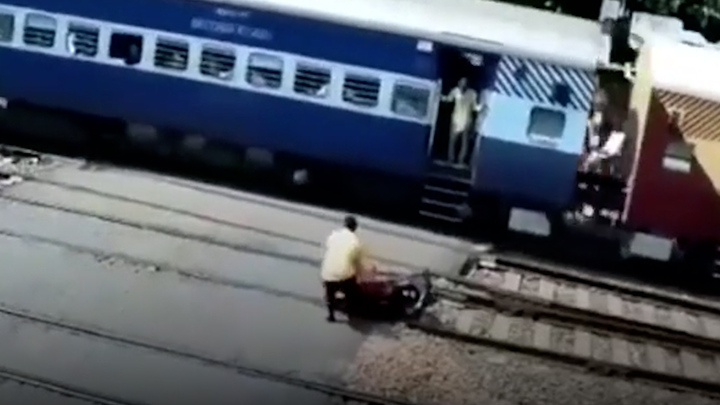 Video: Khoảnh khắc người đàn ông cố kéo xe máy khỏi đường ray khi tàu đến