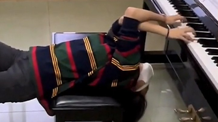 Cô gái trình diễn piano ở tư thế kỳ lạ