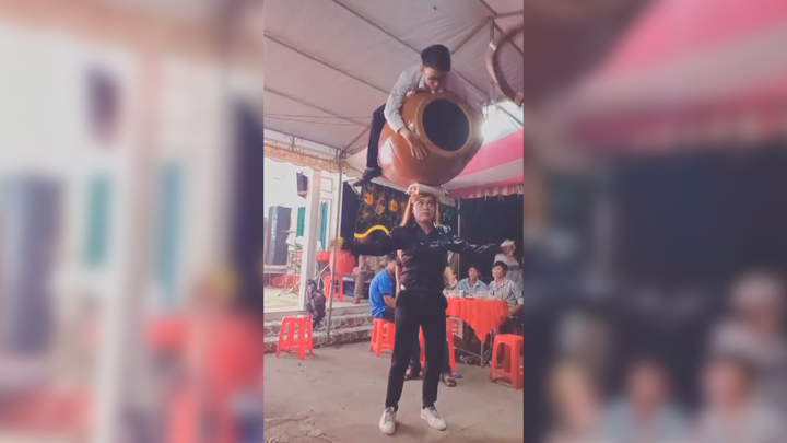 Kinh ngạc người phụ nữ giữ thăng bằng chiếc bình gốm và người đàn ông trên đầu