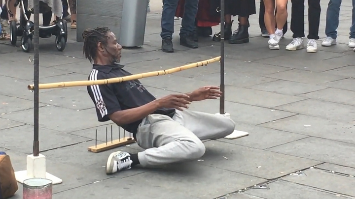 Nghệ sĩ đường phố gập người sát đất chui qua thanh chắn ở Anh