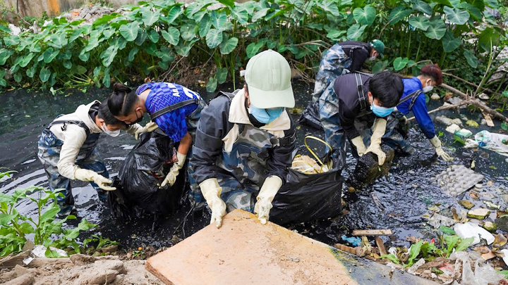 Nhóm bạn trẻ ngâm mình vớt rác dưới dòng kênh đen kịt ở Hà Nội