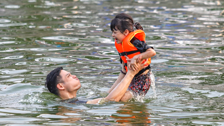 Trời nắng, phụ huynh đưa con nhỏ ra bơi ở ao làng