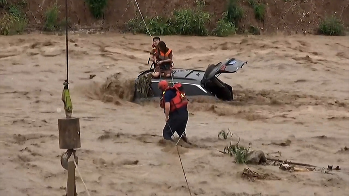 Phớt lờ cảnh báo, đội nam nữ mắc kẹt trên ô tô giữa dòng nước lũ 