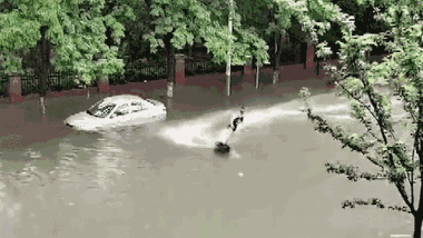 Đường phố chìm trong biển nước, người đàn ông trổ tài lướt ván