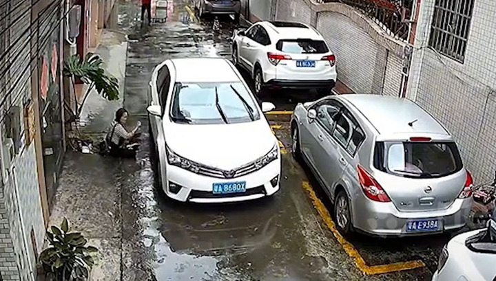 Đi bộ mất thăng bằng, người phụ nữ ngã vào ô tô đang lao tới 