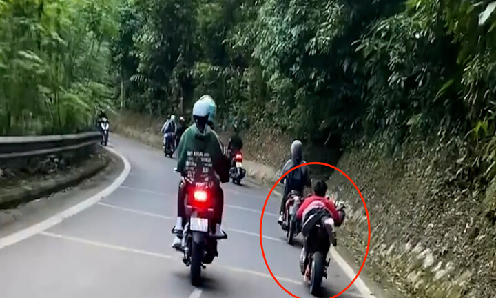 Nam thanh niên nằm trên yên xe máy điện, lao vun vút trên đường đèo