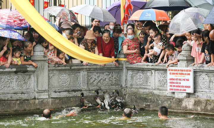 Người dân đội mưa xem bắt vịt ở lễ hội làng Vạn Phúc