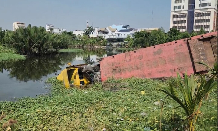 Xe container chở cuộn thép 20 tấn lao xuống hồ nước ven đường ở TP.HCM