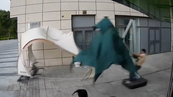 Gió mạnh kéo người đàn ông 'trượt tuyết' trên đường