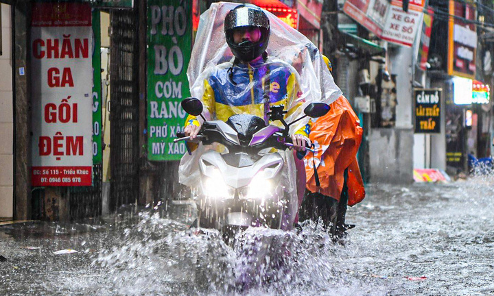 Hà Nội mưa từ sáng đến chiều, xe cộ bì bõm 'bơi' trên đường