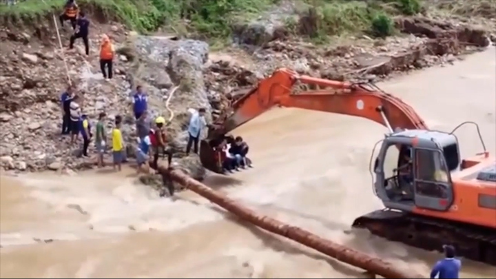 Bất ngờ chuyển dạ, thai phụ ở Thái Lan được máy xúc đưa qua dòng lũ an toàn