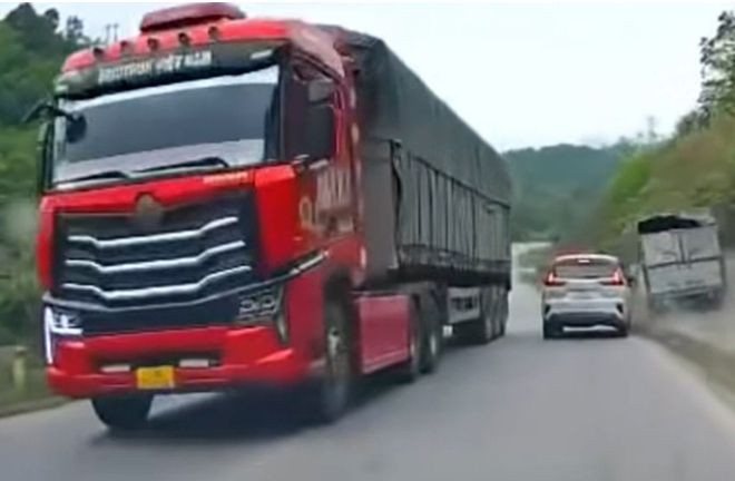 Xe đầu kéo chạy hẳn sang làn ngược chiều để vượt khiến xe tải lao xuống vệ đường