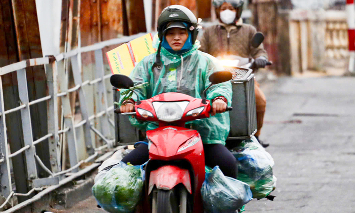 Người Hà Nội khoác áo mưa ra đường từ tờ mờ sáng trong gió rét đầu năm