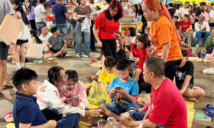 Người dân TP.HCM trải bạt ngồi chờ pháo hoa giao thừa Tết Bính Ngọ