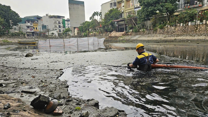 Công nhân ngâm mình trong nước bẩn, nạo vét cống, sông Hà Nội ngày 29 Tết