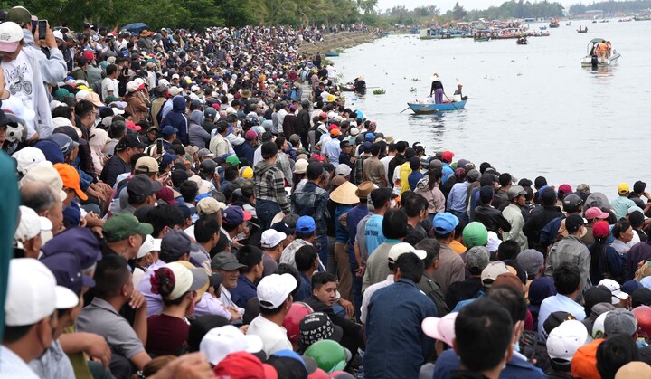 Hàng nghìn người dân và du khách chen chân ken đặc, hò reo cổ vũ đua thuyền trên sông Thu Bồn