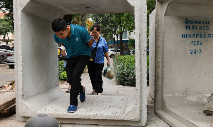 Vỉa hè phố trung tâm Hà Nội bị 'nuốt trọn', người đi bộ phải chui ống bê tông