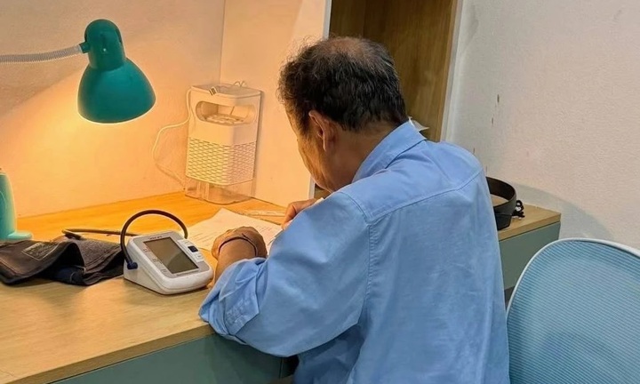 Ông 78 tuổi đặt máy đo huyết áp bên cạnh, kiên trì kèm cháu ôn thi vào lớp 10