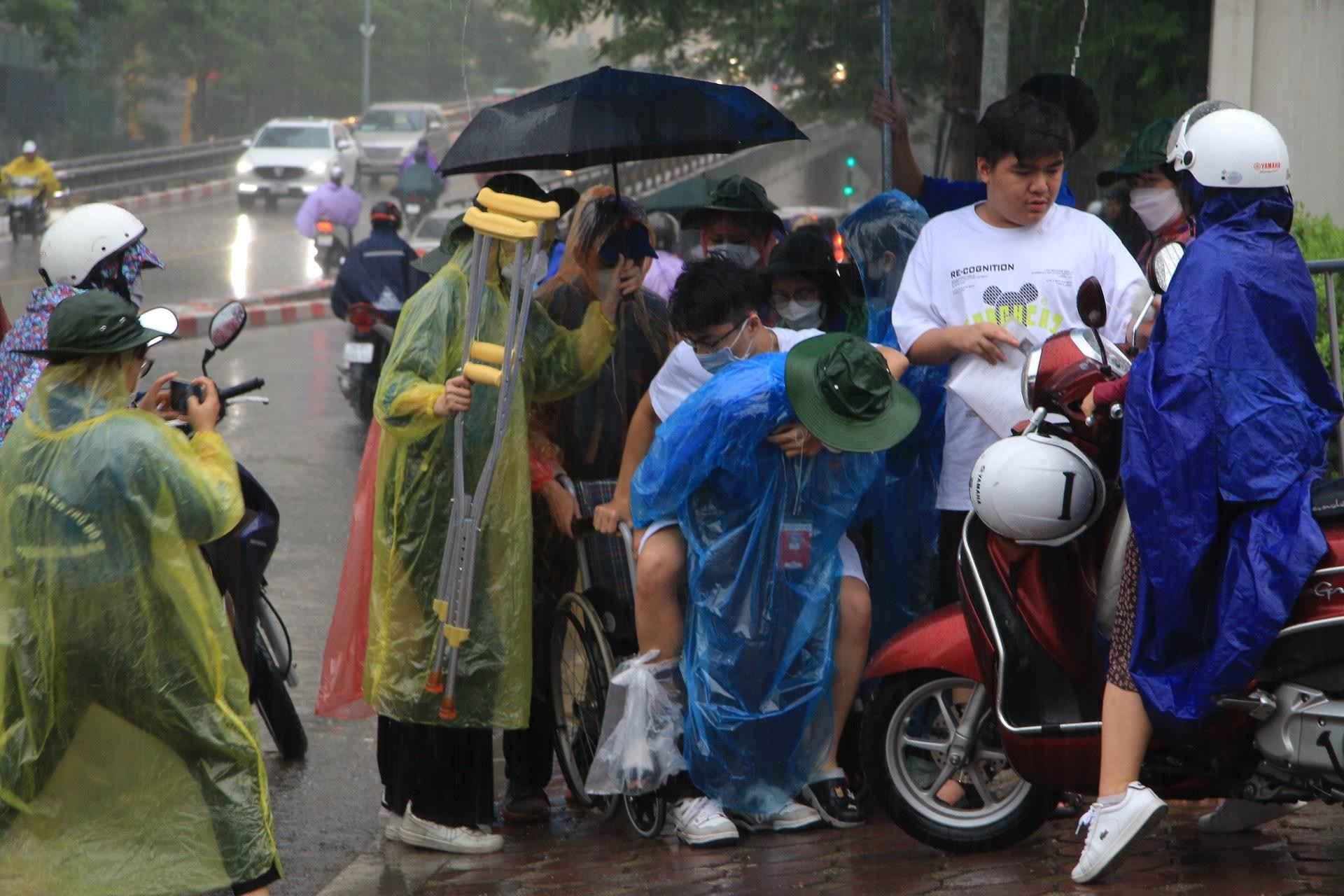 Thí sinh ngồi xe lăn đội mưa đi thi tốt nghiệp THPT - 1