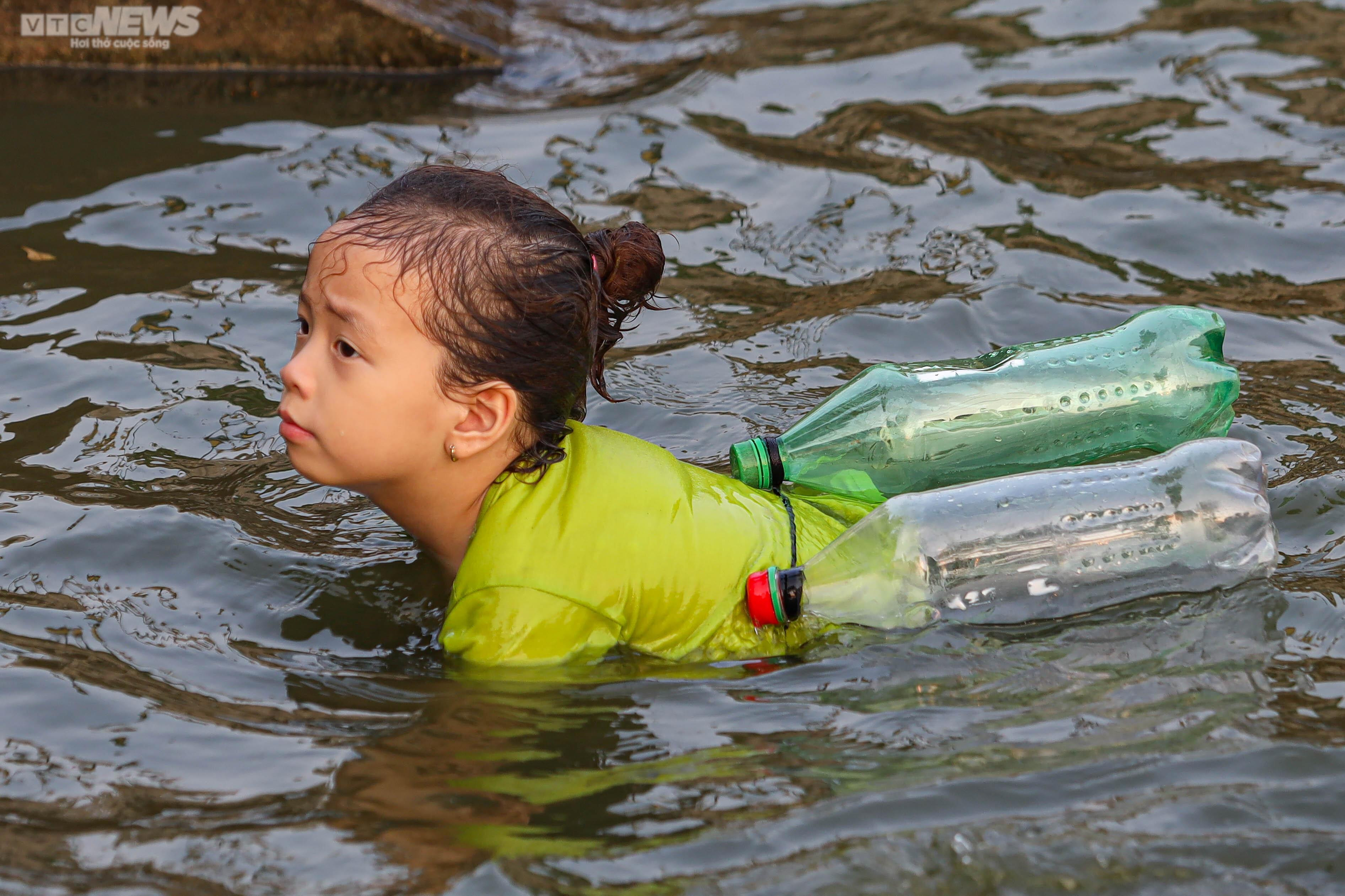 Trời nắng, phụ huynh đưa con nhỏ ra bơi ở ao làng - 10