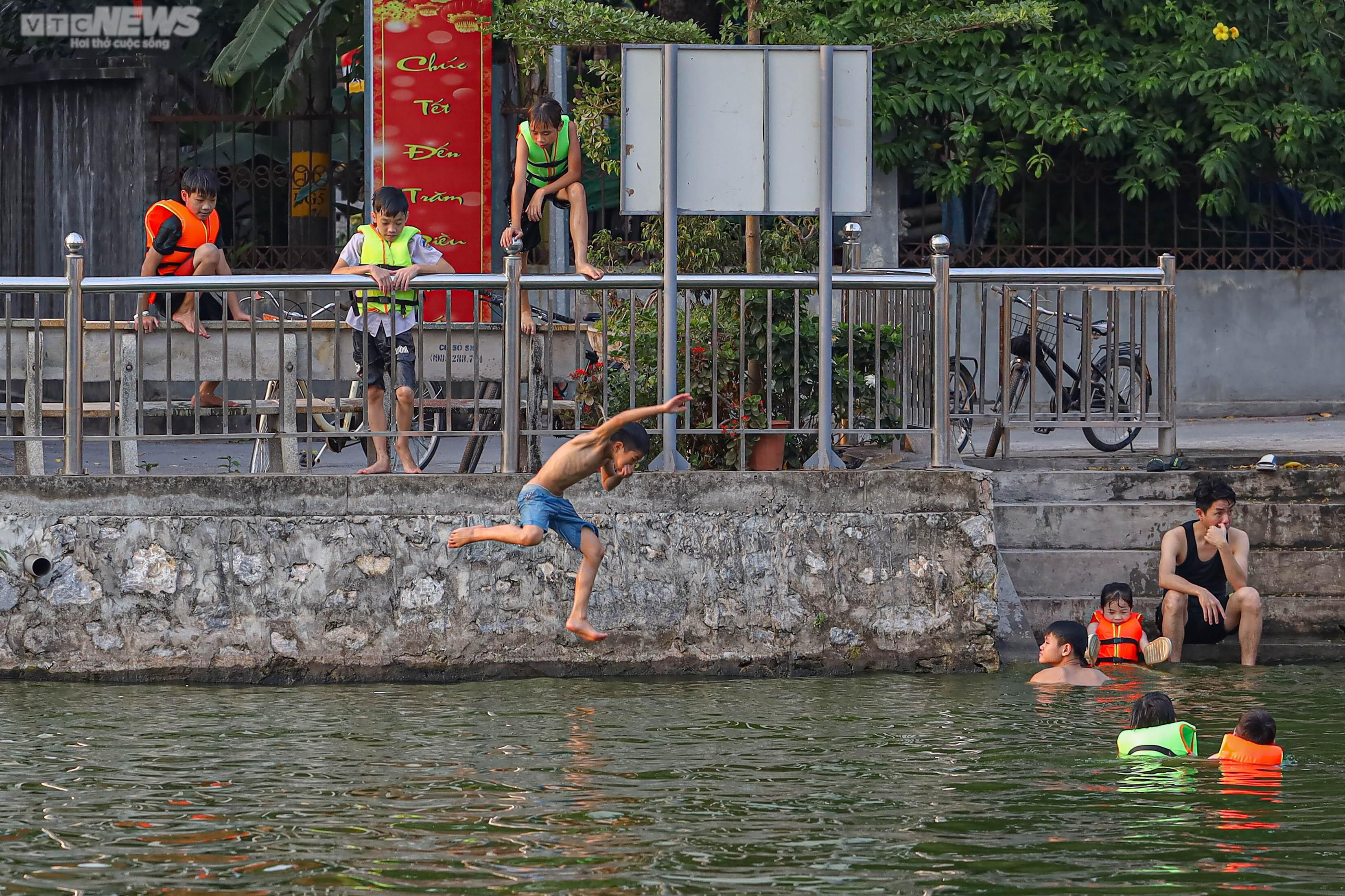 Trời nắng, phụ huynh đưa con nhỏ ra bơi ở ao làng - 12