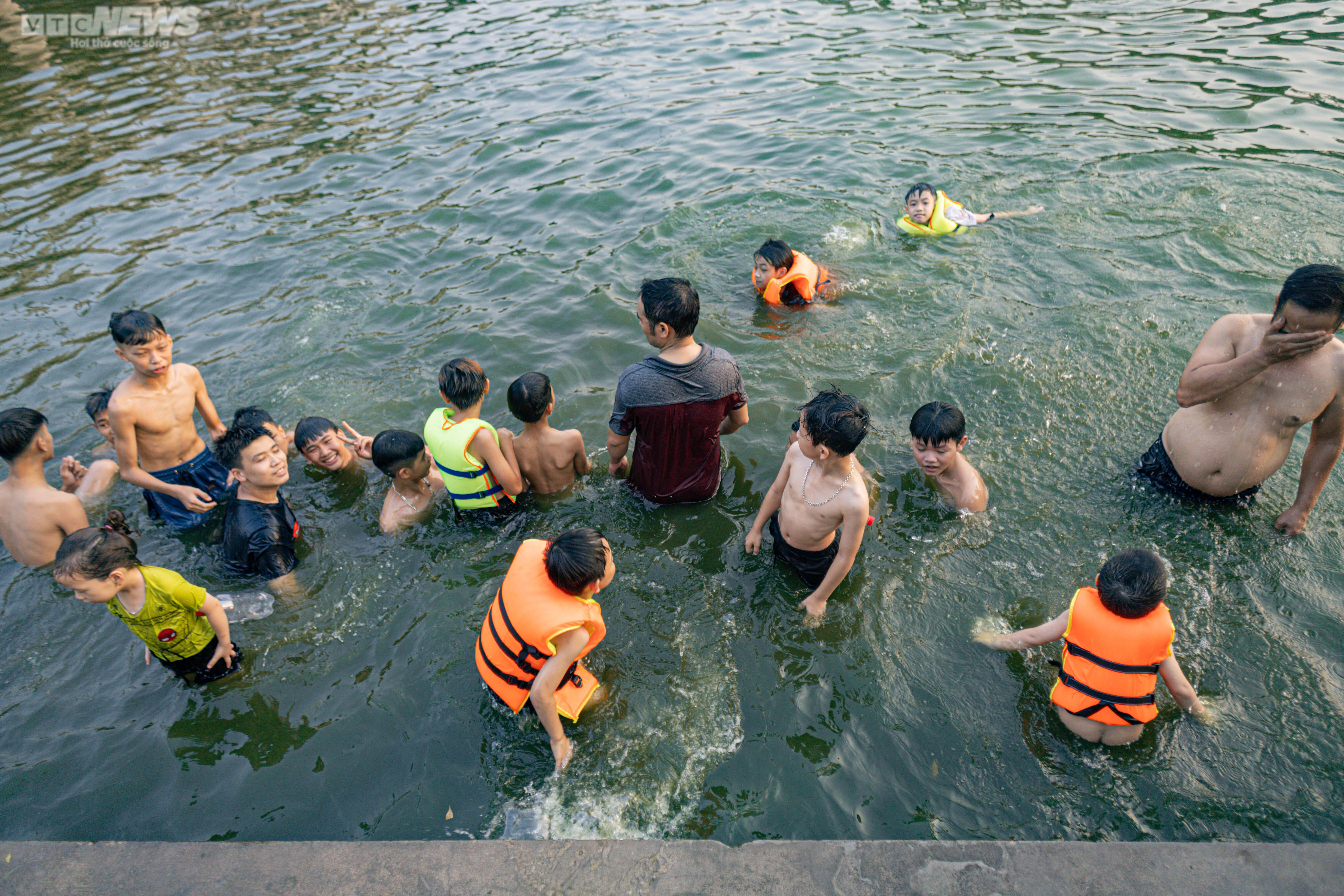Trời nắng, phụ huynh đưa con nhỏ ra bơi ở ao làng - 14