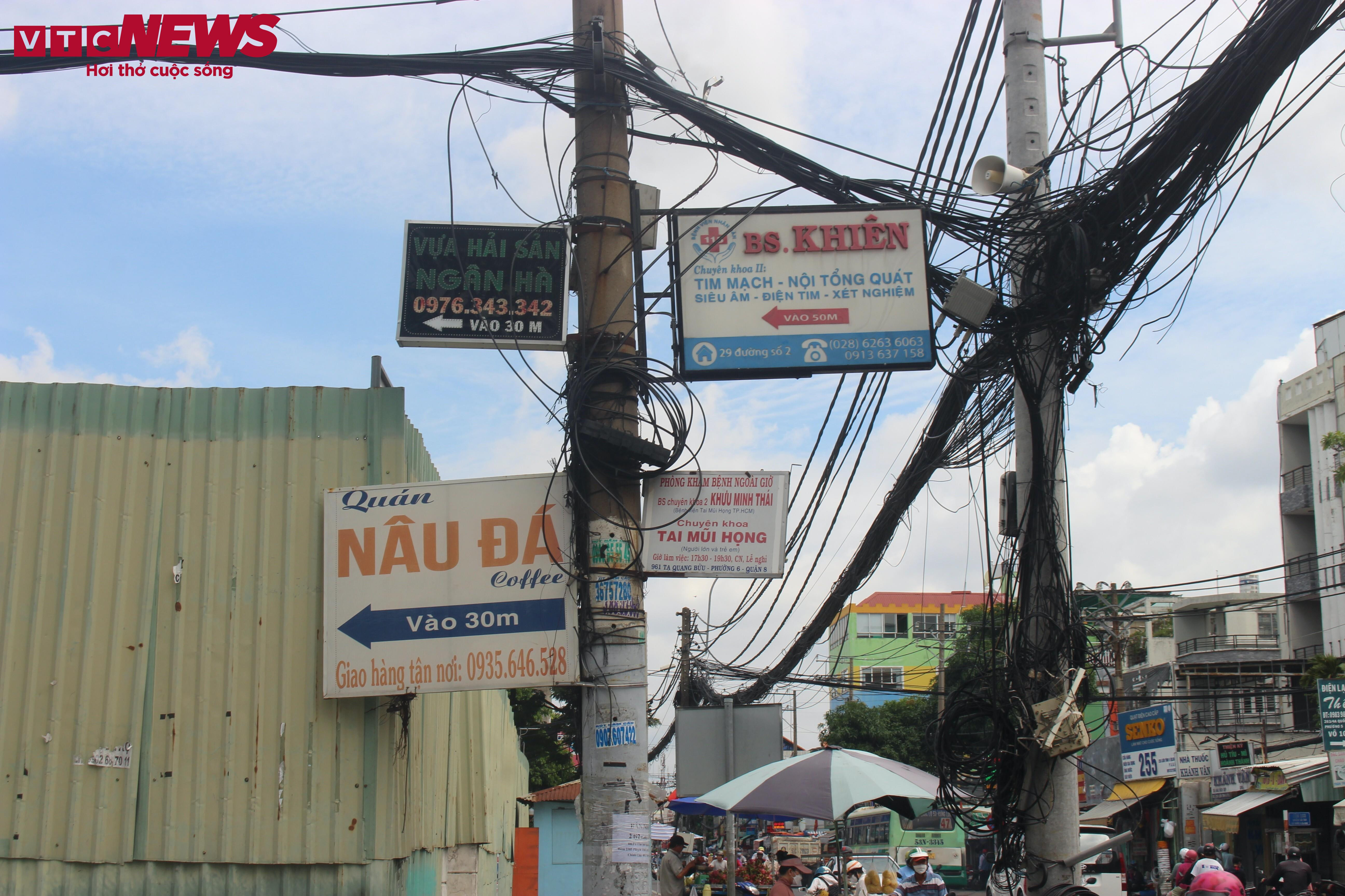 Cột điện, cây xanh ở TP.HCM bị băng rôn, biển quảng cáo bủa vây - 3