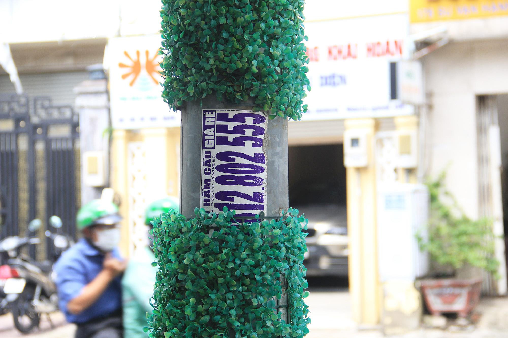 TP.HCM: Hơn 1.000 trụ điện quấn cỏ nhựa vẫn chi chít quảng cáo hút hầm cầu - 7