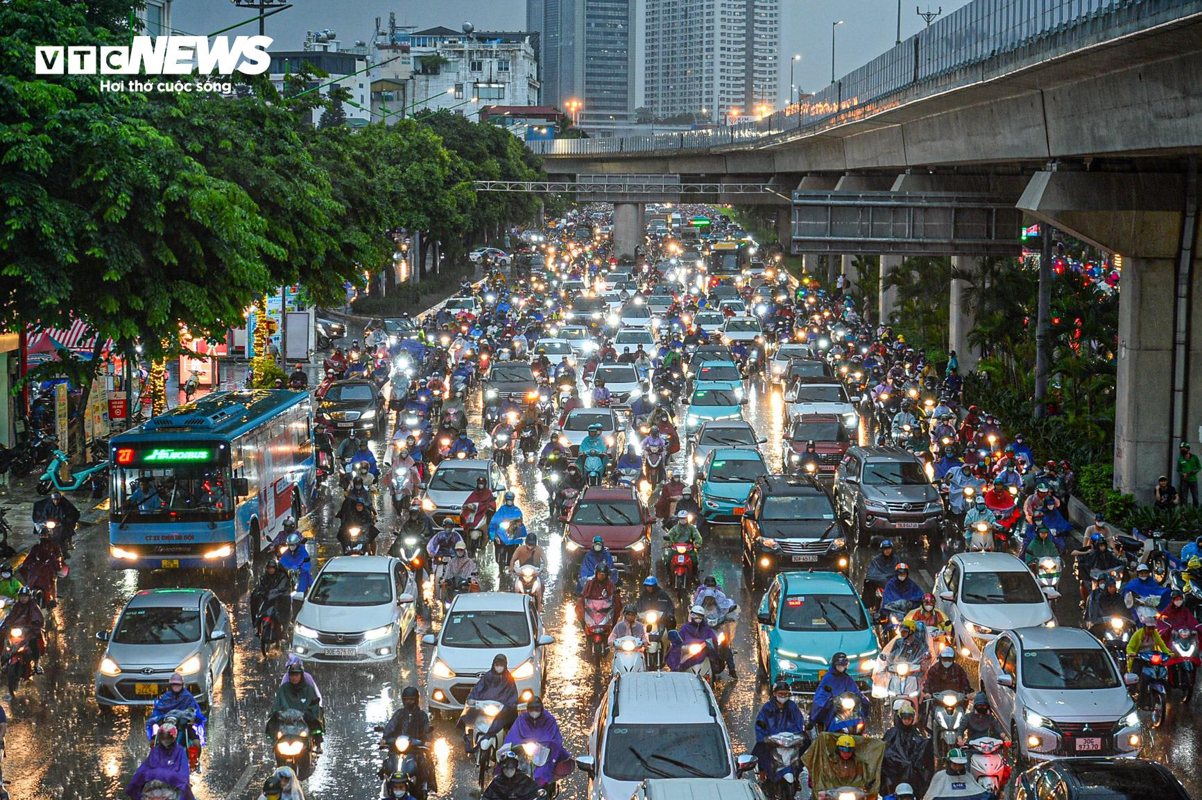 Mưa xối xả giờ tan tầm, người Hà Nội phải trú tạm gầm cầu - 1