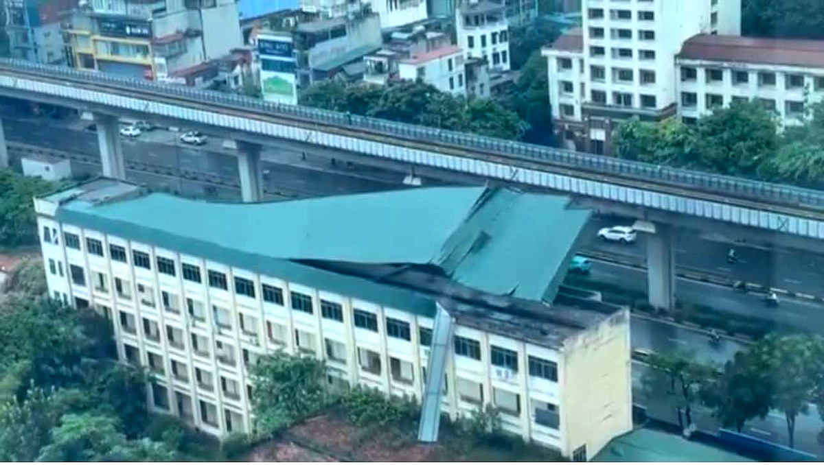 Mái tôn tại Công ty Giày Thượng Đình (đường Nguyễn Trãi, quận Thanh Xuân) bị gió bão "bóc" khỏi tòa nhà, bung ra, rơi xuống bãi ô tô phía dưới.