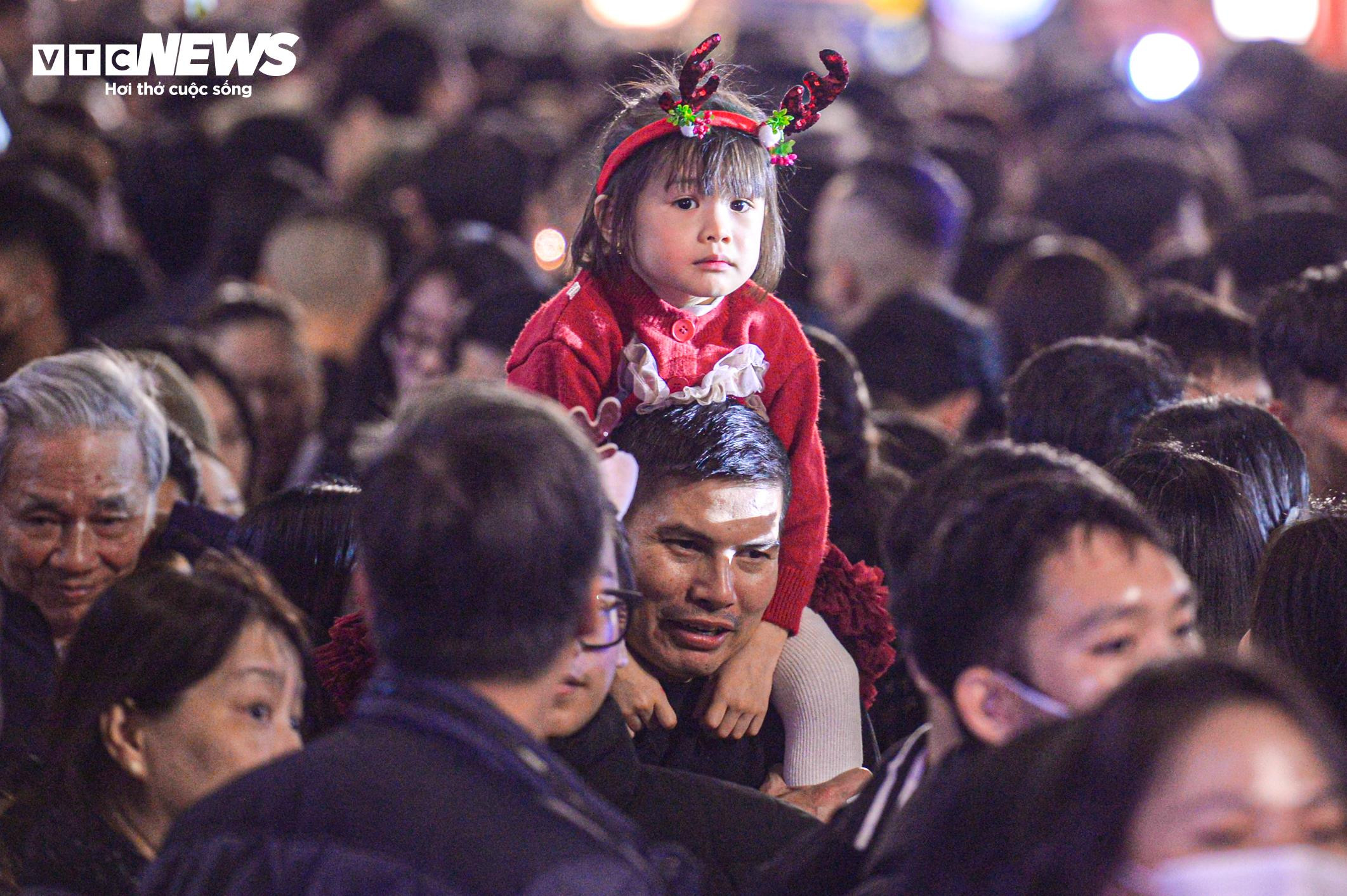 Trẻ nhỏ bơ phờ, ngồi trên lưng bố mẹ vượt biển người đêm Giáng sinh - 10