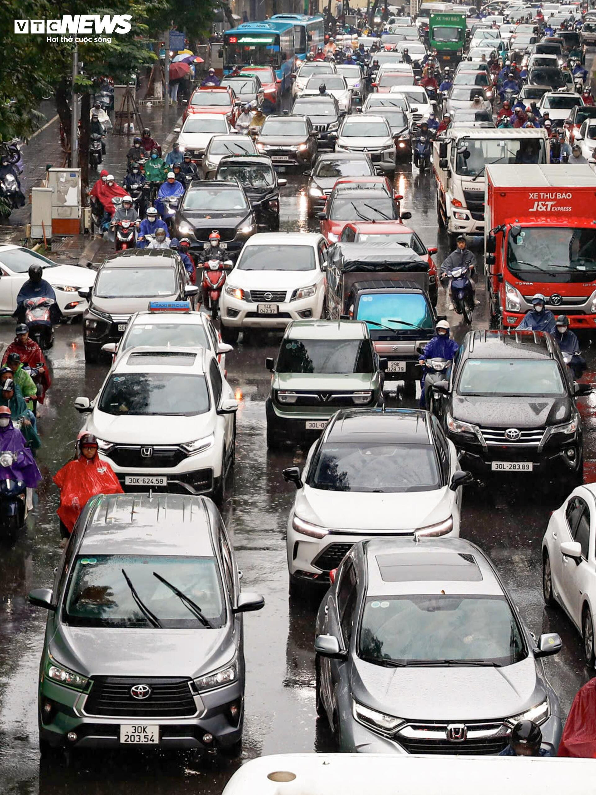 Chật vật trong mưa lạnh, người dân ở Hà Nội nhích từng mét đến công sở - 4