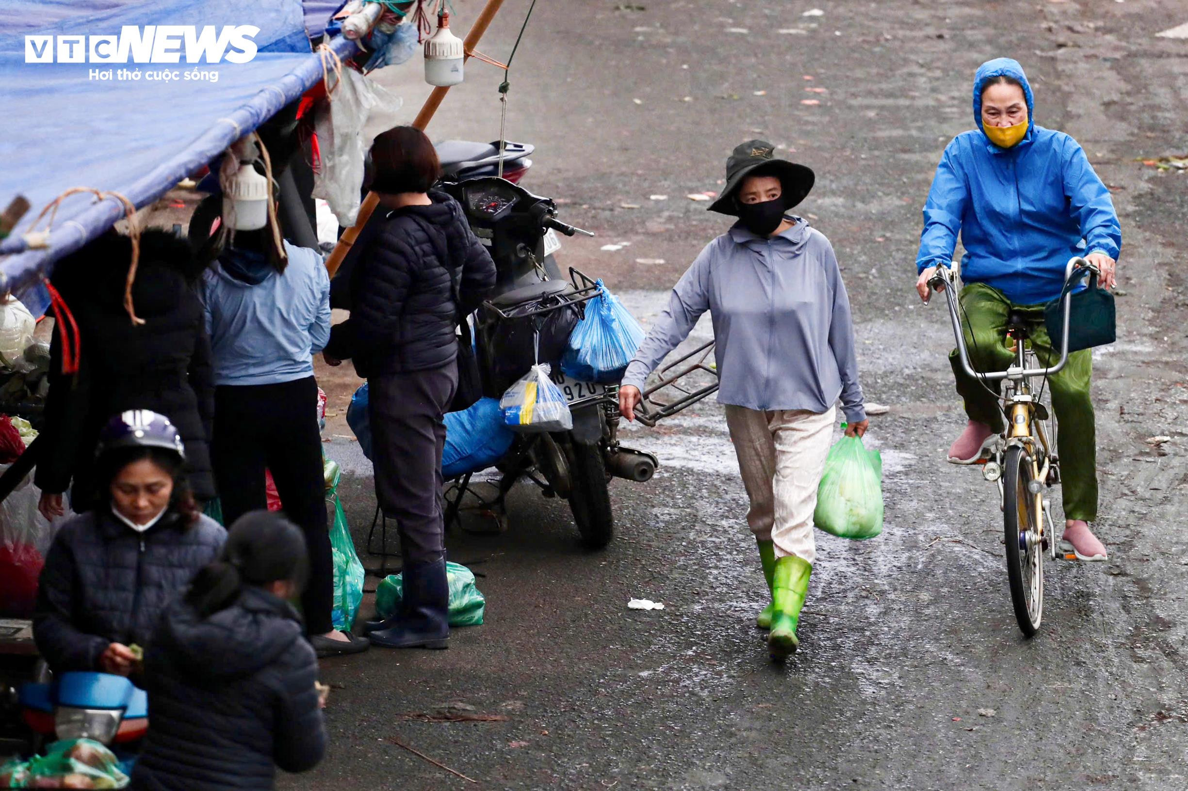 Người Hà Nội khoác áo mưa ra đường từ tờ mờ sáng trong gió rét đầu năm - 7
