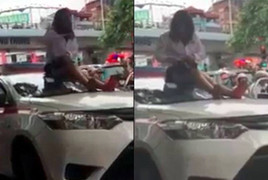 Bị CSGT dừng xe, nữ tài xế taxi vượt đèn đỏ trèo lên nóc xe ăn vạ