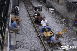 Ảnh: Khách nước ngoài thích thú ngồi uống cà phê trên đường ray tàu hỏa ở Hà Nội