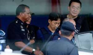 Nghi phạm Triều Tiên mặc áo chống đạn rời khỏi đồn cảnh sát sau khi được thả