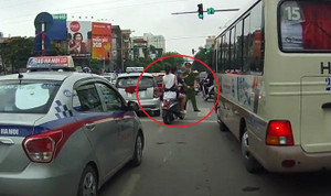 Đôi nam nữ không đội mũ bảo hiểm vẫn luồn lách bị cảnh sát cầm dùi cui vụt