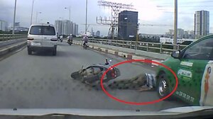 Xe máy ngã văng, thoát chết ngoạn mục trước đầu taxi ở TP.HCM